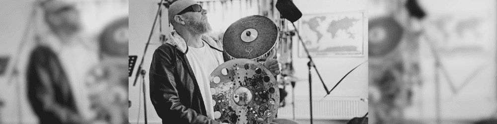 Drummer and percussionist Rudiger Maul playing in his music studio, surrounded by various percussion instruments.