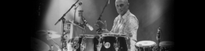 José Cortijo, a talented drummer and percussionist, performing on stage surrounded by his instruments.