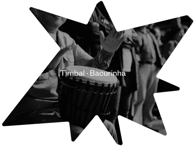 Musician performing live on stage with a Timbal Bacurinha drum.
