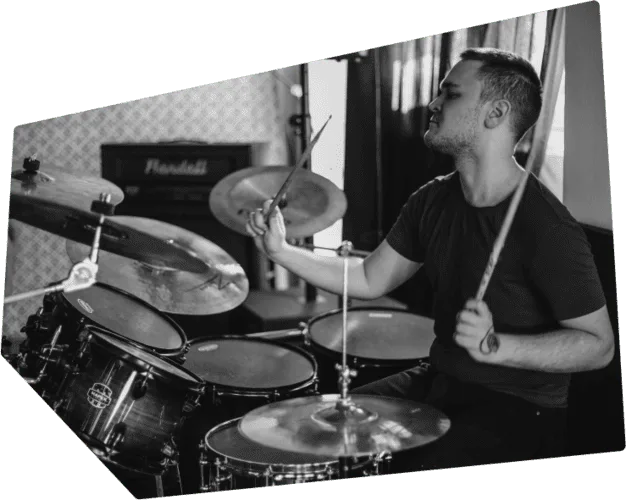 Drummer playing and having fun while practicing on his drum set.